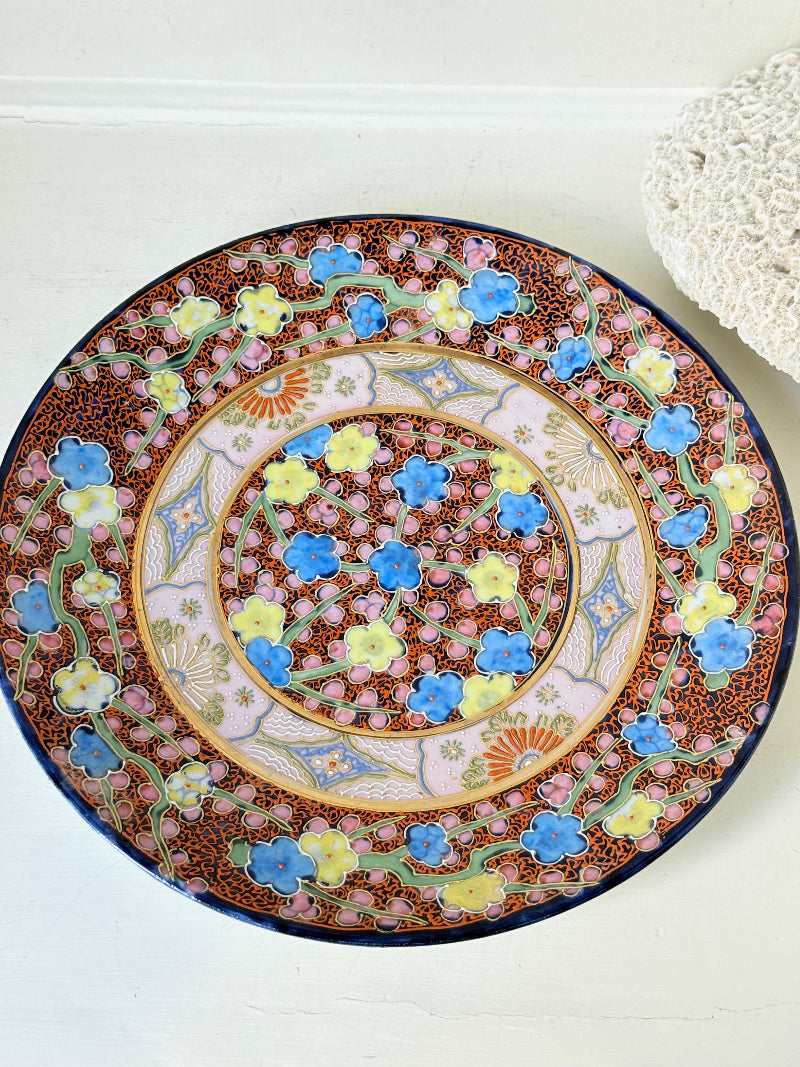 Antique Japanese Aoki Brothers platter with colourful Imari style floral pattern photographed on a white surface