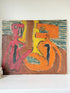 An abstract expressionist painting on canvas featuring two stylized human figures in pink and orange, set against a brown and yellow background with textured teal stripes. The painting is displayed leaning against a white wall on a white shelf.