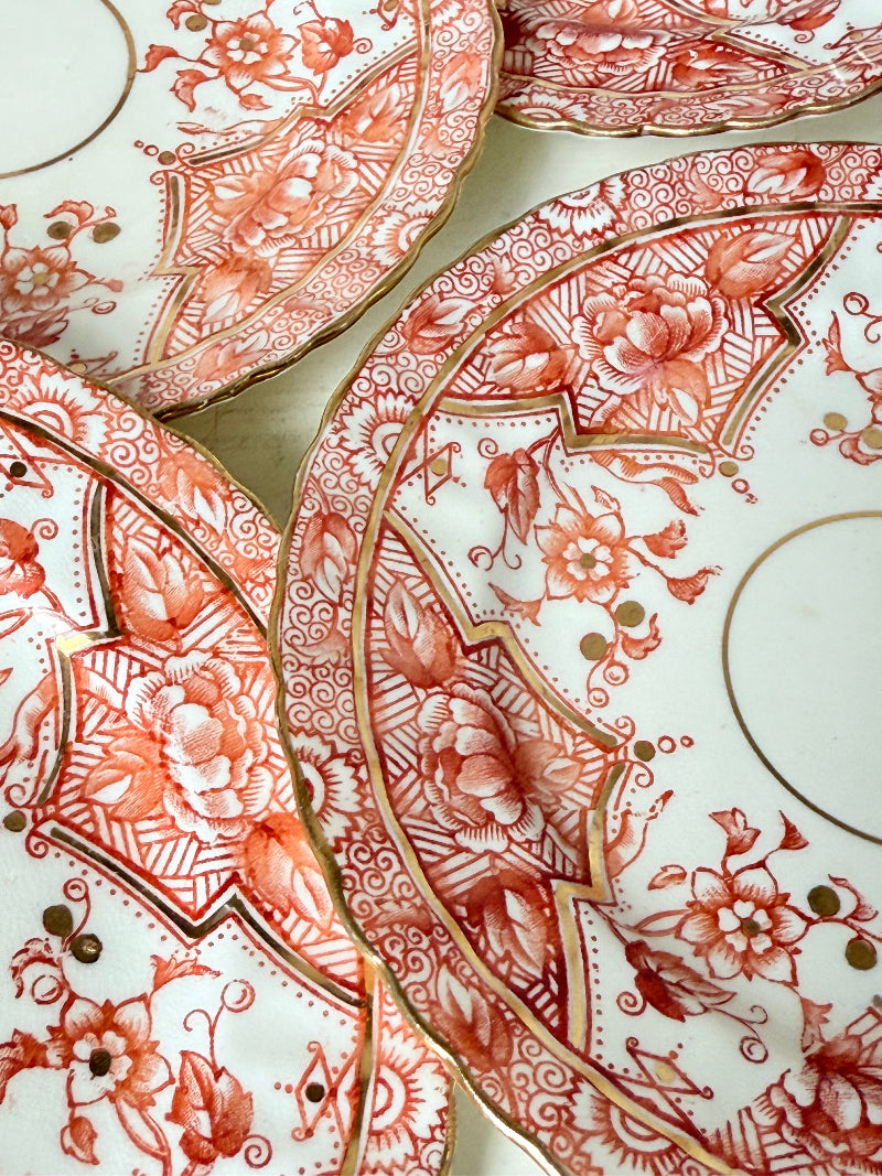 Set of 12 vintage coral transferware porcelain plates with scalloped edges and gold accents, 15 cm diameter, styled on a white surface.