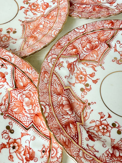 Set of 12 vintage coral transferware porcelain plates with scalloped edges and gold accents, 15 cm diameter, styled on a white surface.