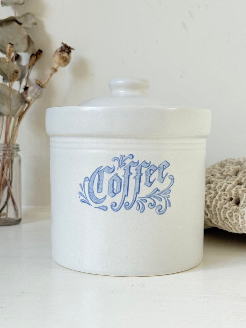 Pfaltzgraff Yorktowne stoneware coffee jar with blue floral motif and lid, photographed on a white surface