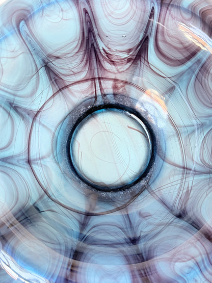 George Davidson blue cloud glass bowl with purple marbled swirls, photographed on a white surface