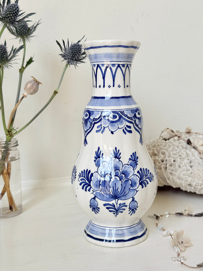 Vintage Delft style blue and white pottery vase with hand painted floral decoration, photographed on a white surface
