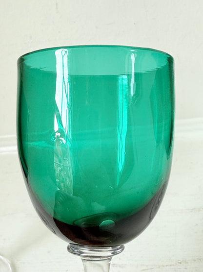 Antique set of four Bristol green liqueur glasses with clear stems, photographed on a white surface