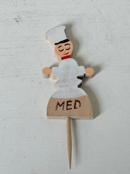Vintage hand painted wooden steak markers on cocktail sticks labelled rare medium and well done, photographed on a white surface