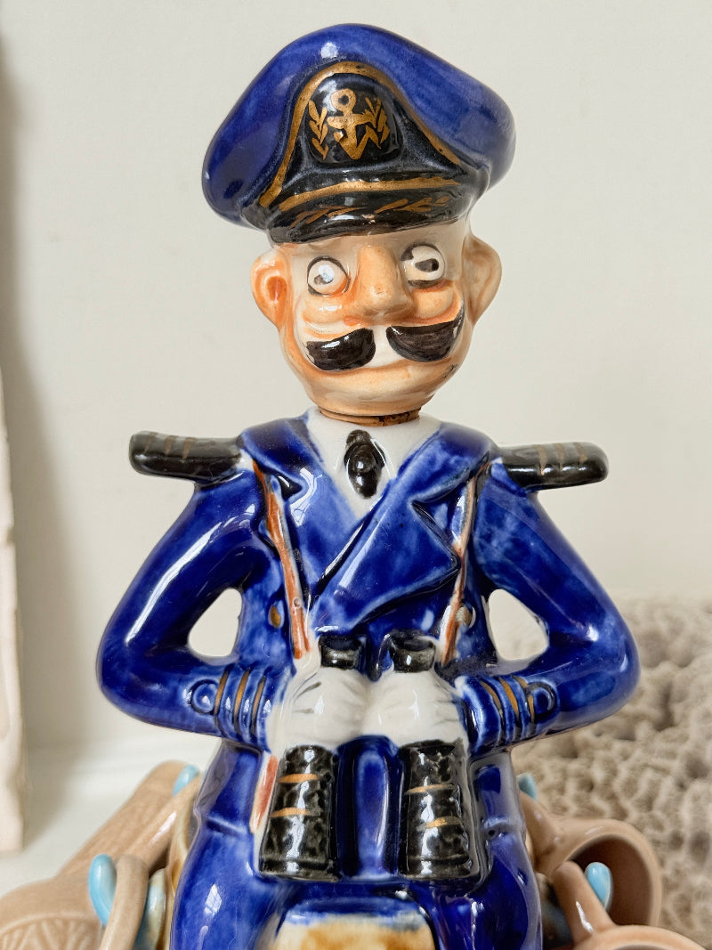Vintage figural ceramic decanter set with captain, navy blue uniform, barrel base and 6 matching barrel shot cups