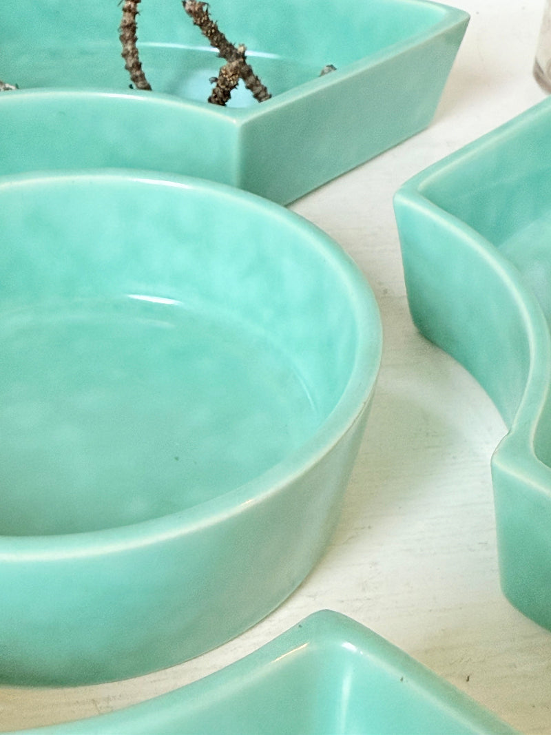 Poole Pottery turquoise hors d’oeuvre dishes set of five displayed on a white surface.