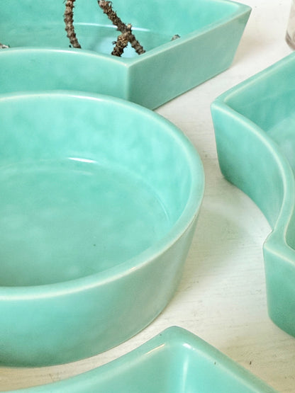 Poole Pottery turquoise hors d’oeuvre dishes set of five displayed on a white surface.