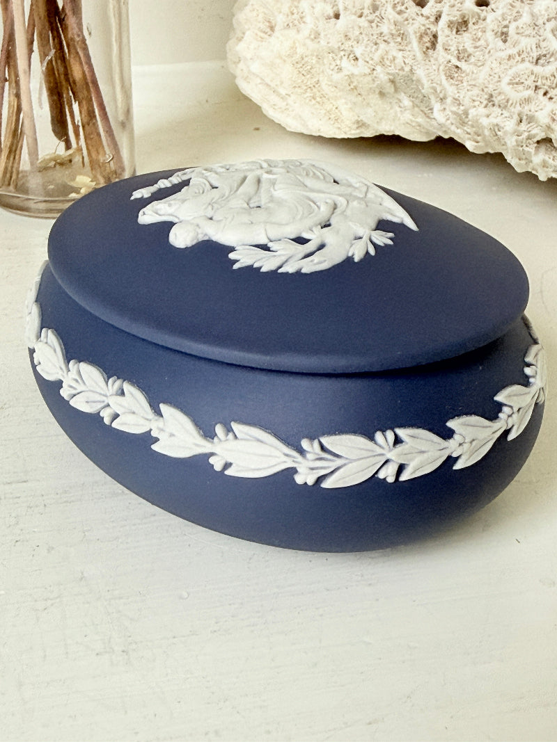 Vintage Wedgwood Jasperware Portland blue round lidded trinket box, decorated with a white neoclassical cameo and laurel wreath border.