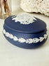 Vintage Wedgwood Jasperware Portland blue round lidded trinket box, decorated with a white neoclassical cameo and laurel wreath border.