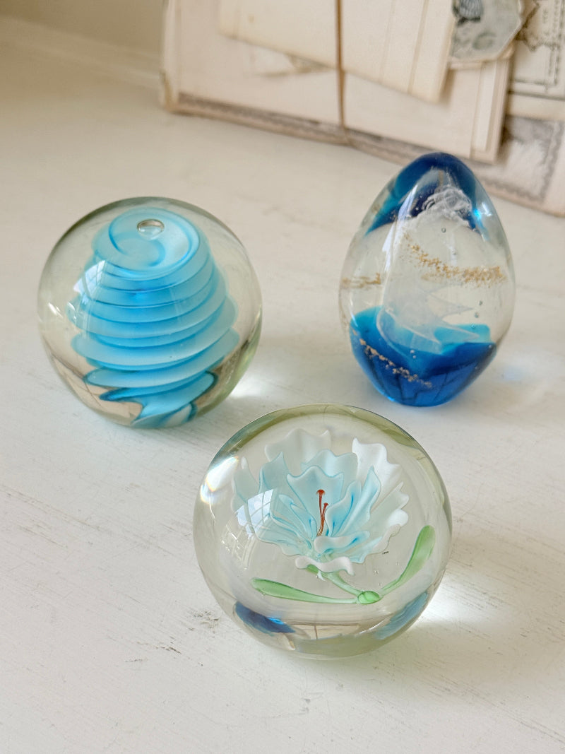 Trio of vintage turquoise blue glass paperweights with swirl, ribbed and floral detail in clear coloured glass