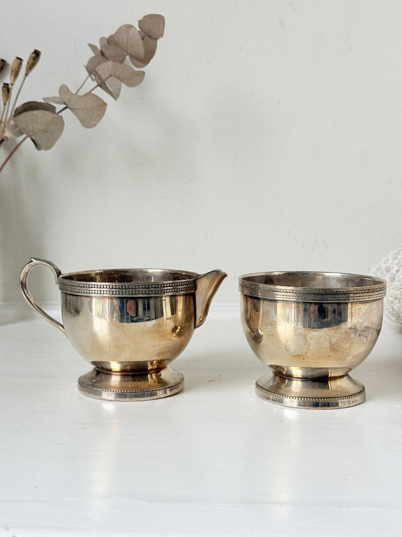 Vintage silver plated on brass sugar bowl and milk jug set, photographed on a white surface