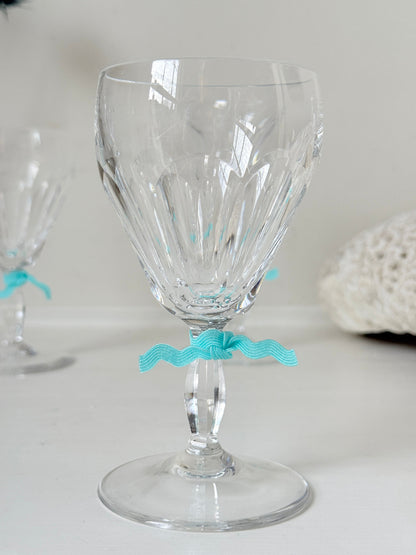 Set of four vintage cut crystal aperitif glasses with faceted bowls, photographed on a white surface