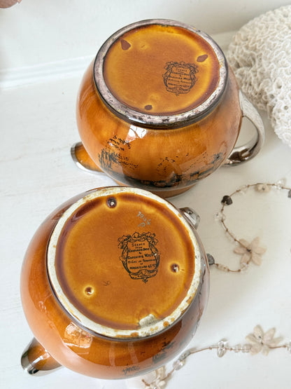 Pair of vintage Ridgways Coaching Days and Coaching Ways treacle jugs in amber brown glaze photographed on a white surface