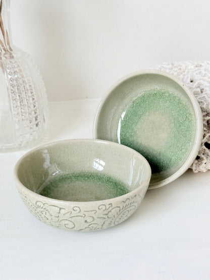 Pair of sage green Thai celadon olive bowls with crackled glaze, photographed on white surface