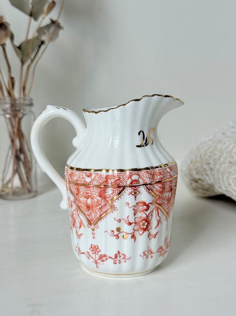 vintage porcelain milk jug with coral transfer design and gilt detailing on white surface