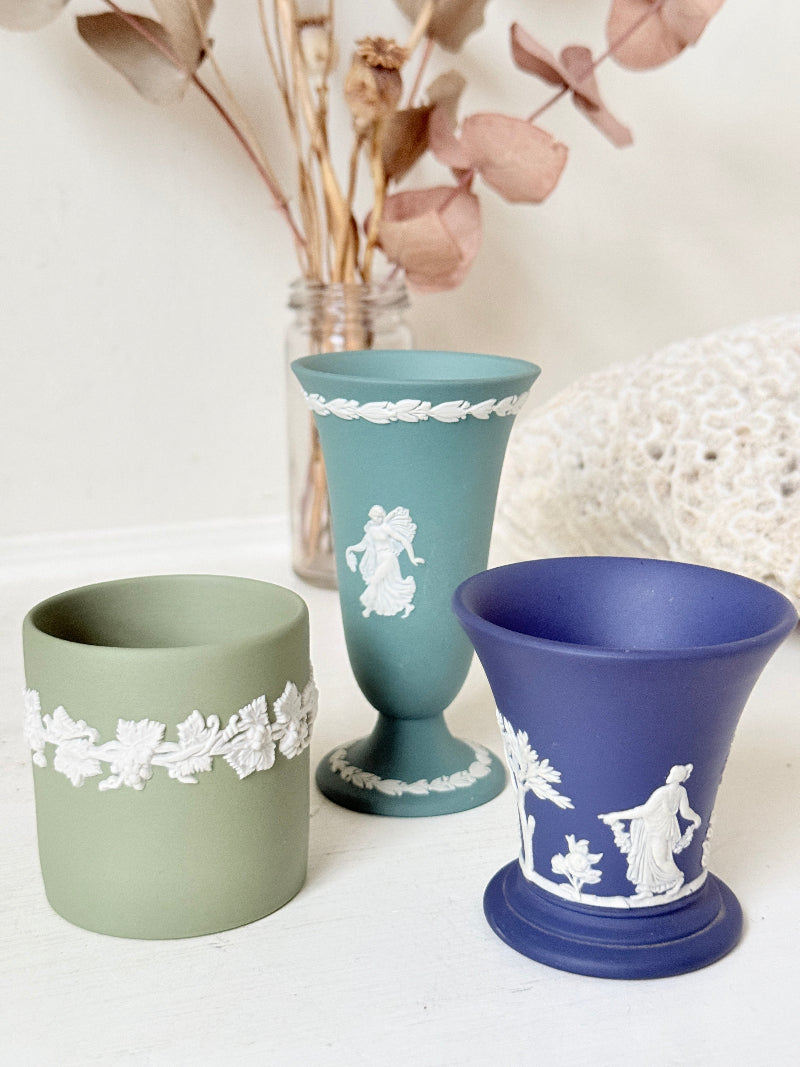 Trio of vintage Wedgwood Jasperware vases in green and blue with white relief decoration, photographed on a white surface