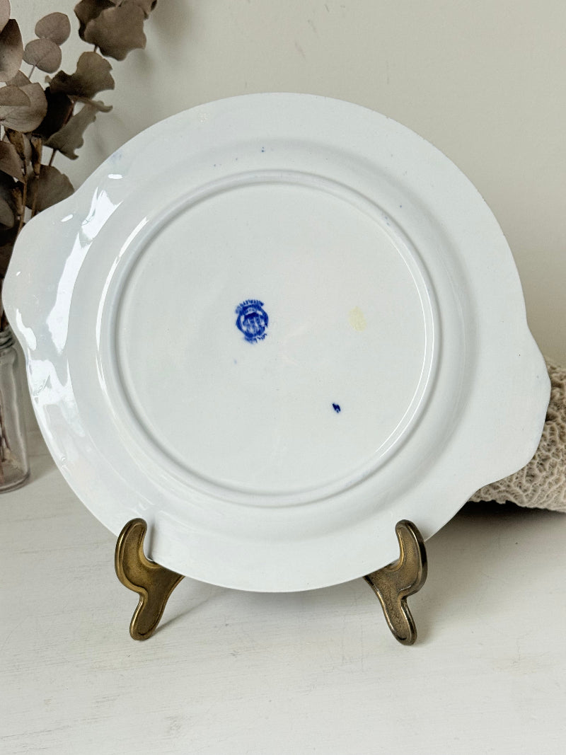 Blue Willow serving plate with scroll handled relief shown on a white surface.