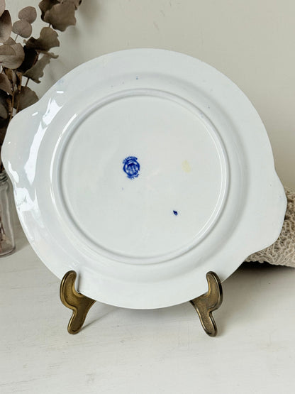 Blue Willow serving plate with scroll handled relief shown on a white surface.