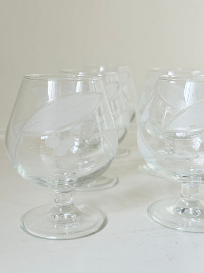 Set of six vintage etched Bailey’s glasses with rounded bowls and short stems, photographed on white surface.