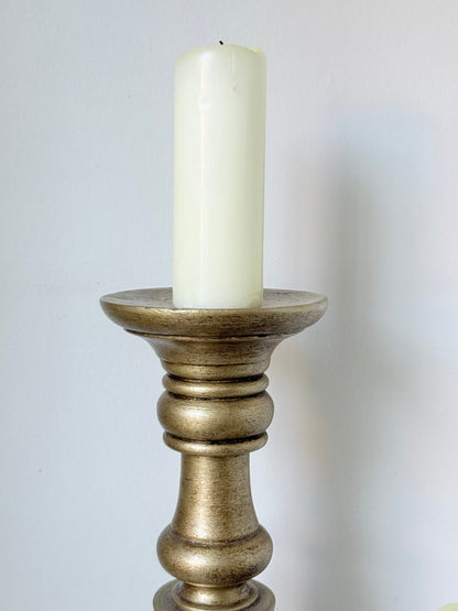 Pair of vintage wooden candlesticks, one tall and one small, in golden-toned finish, styled with pillar candles on a white surface.