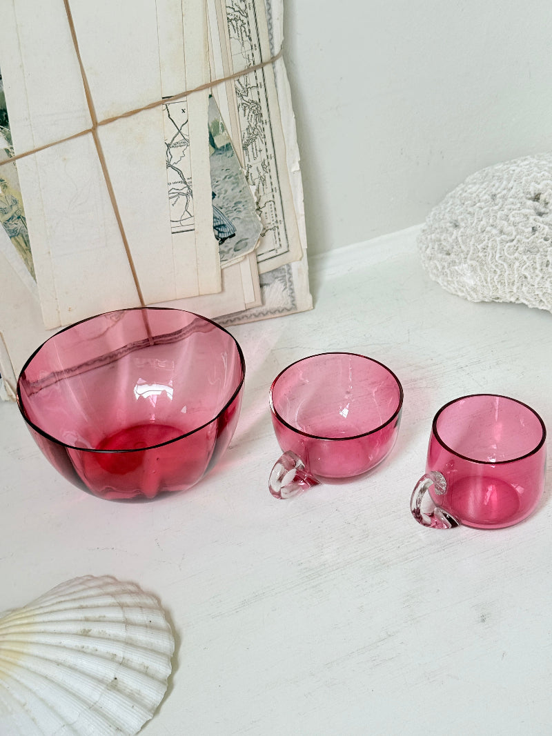 Trio of antique cranberry glass with sugar bowl, teacup, coffee can, clear glass handles and deep pink glass