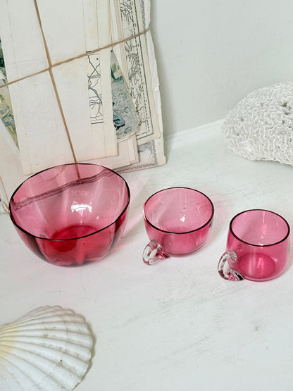 Trio of antique cranberry glass with sugar bowl, teacup, coffee can, clear glass handles and deep pink glass