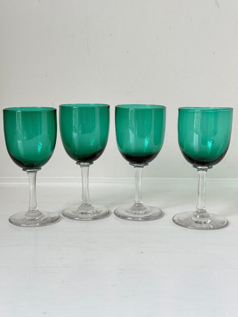 Antique set of four Bristol green liqueur glasses with clear stems, photographed on a white surface