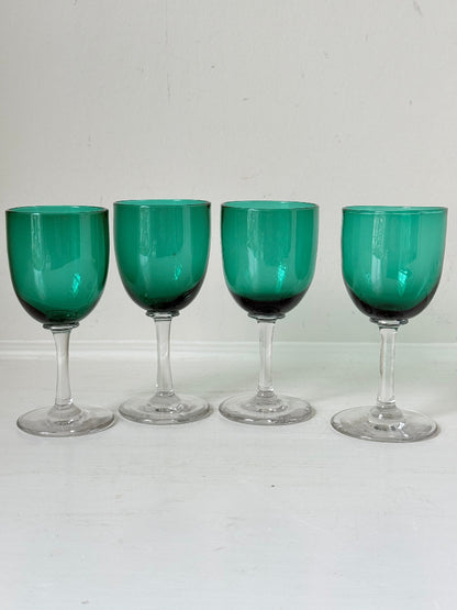 Antique set of four Bristol green liqueur glasses with clear stems, photographed on a white surface