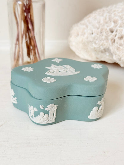 Vintage Wedgwood Jasperware teal green lidded trinket box in a quatrefoil shape, decorated with white neoclassical figures and florets, styled with dried stems.