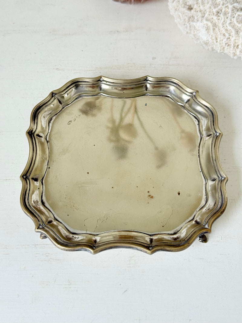 Vintage silver plate tray with scalloped edge and footed base, photographed on a white surface