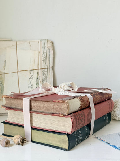 Large vintage decorative book bundle with burgundy cream and green hardback covers tied with ribbon for interior styling