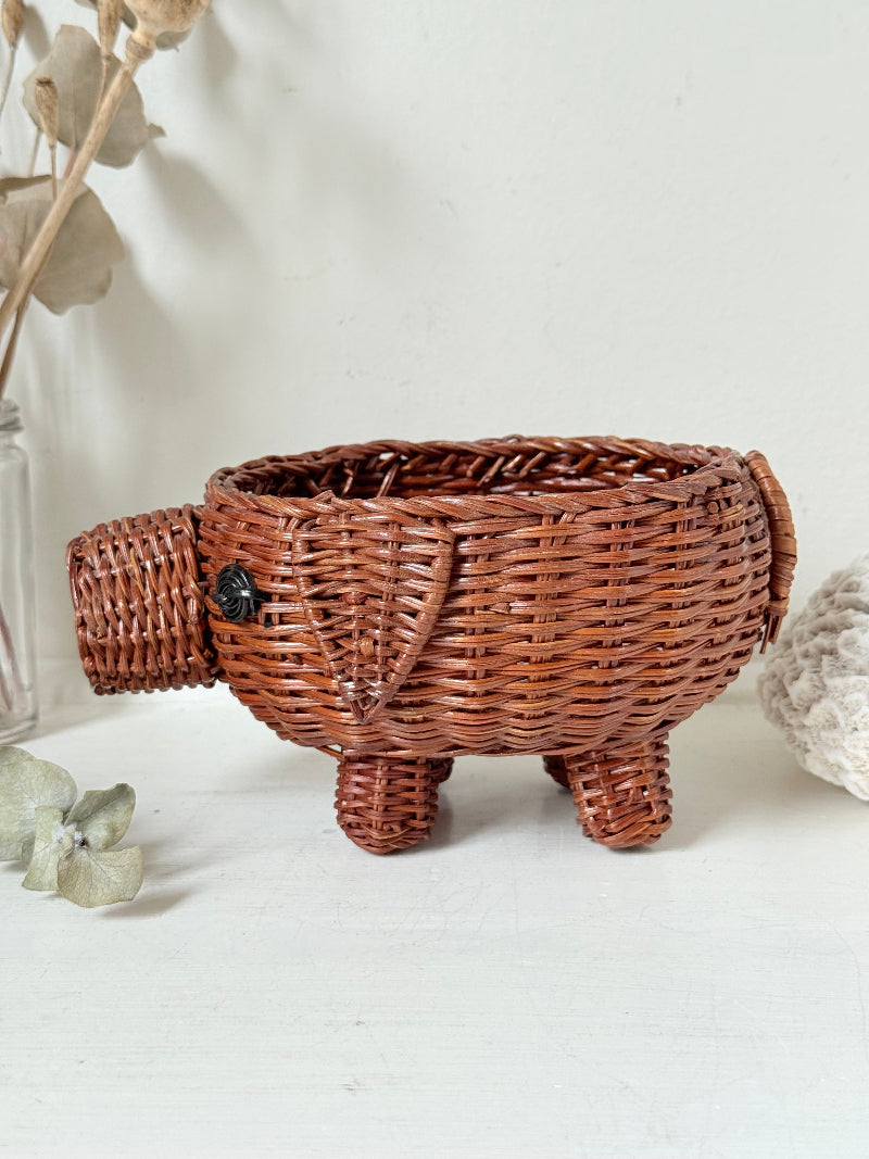 Vintage wicker pig basket planter in warm brown, photographed on a white surface