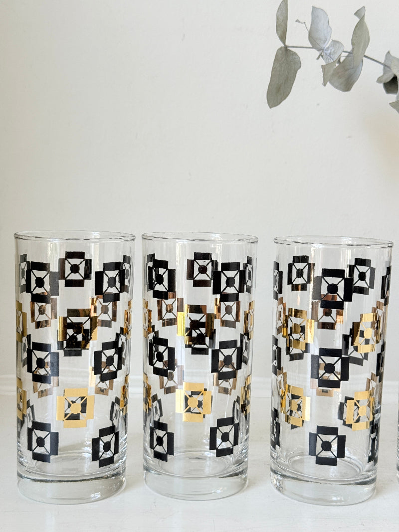 Mid century black and gold glass drinks set with jug and five highball tumblers in a geometric medallion pattern