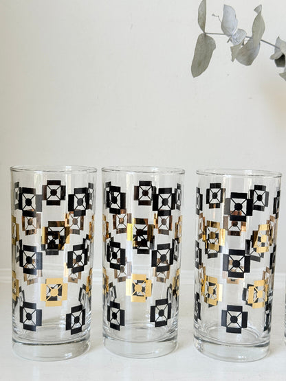 Mid century black and gold glass drinks set with jug and five highball tumblers in a geometric medallion pattern