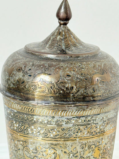 Indian Benares brass jar with lid and engraved animals and floral design, photographed on a white surface