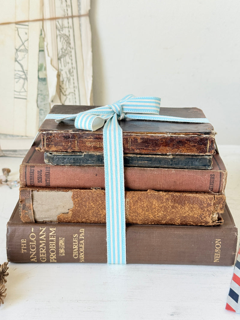 Vintage decorative brown book bundle with aged hardback covers tied with blue stripe ribbon for bookshelf and table styling
