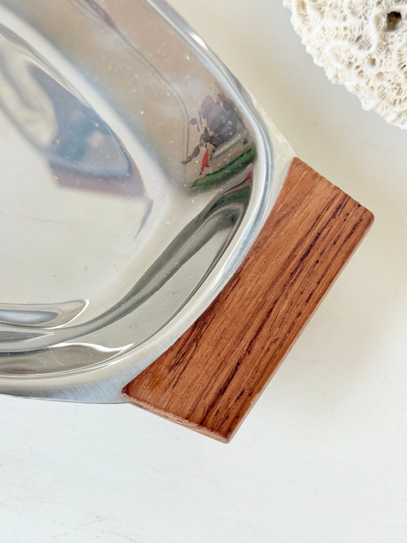 Pair of mid century stainless steel and teak crudites dishes photographed on a white surface