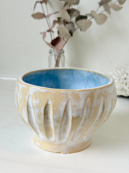 Vintage studio pottery bowl planter in cream and sky blue glaze photographed on a white surface