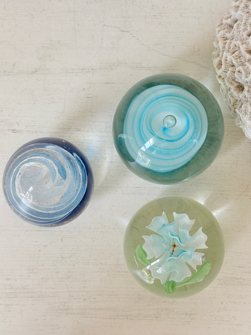 Trio of vintage turquoise blue glass paperweights with swirl, ribbed and floral detail in clear coloured glass
