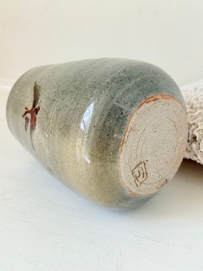 Hand thrown studio pottery vase with ash glaze and brushstroke motif, photographed on white surface