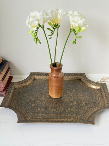 Vintage hand engraved brass wall plaque with floral scrollwork, figural decoration, shaped edge and aged patina