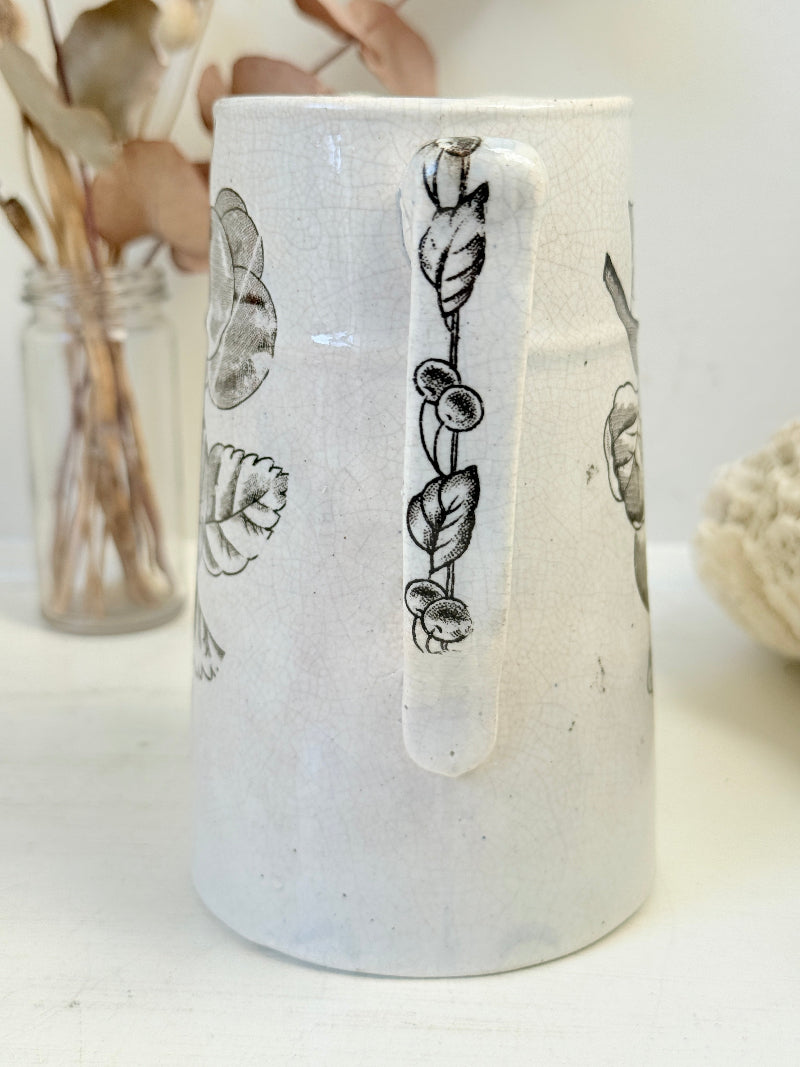 Antique English transferware jug with black fruit and leaf design, photographed on a white surface