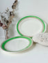 Pair of vintage oval serving platters with bright green Art Deco style border photographed on a white surface