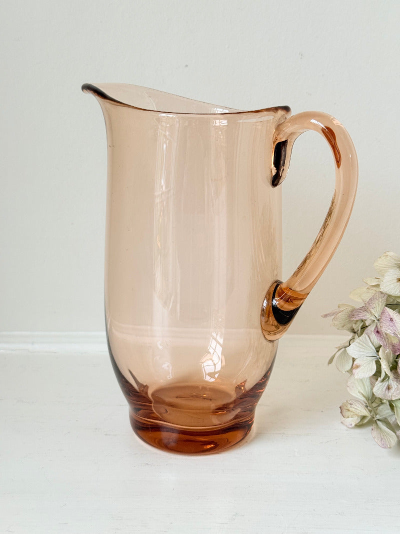 retro apricot glass serving jug with curved handle and flared spout, photographed on white surface