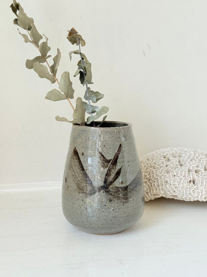 Hand thrown studio pottery vase with ash glaze and brushstroke motif, photographed on white surface