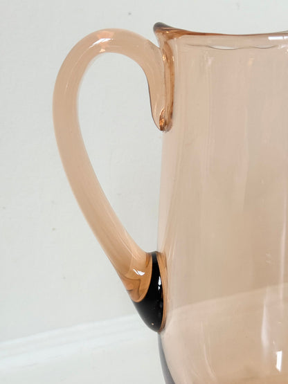 retro apricot glass serving jug with curved handle and flared spout, photographed on white surface