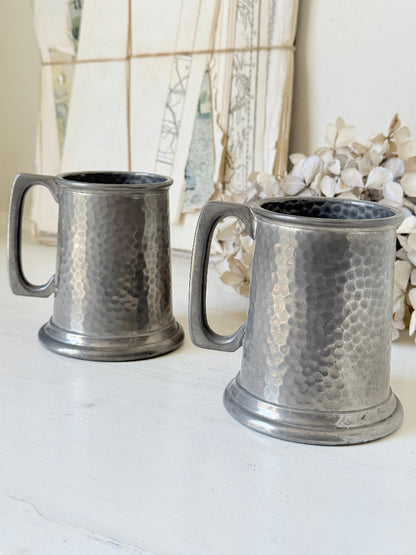 Pair of hammered English pewter tankards by E H Parkin of Sheffield, photographed on a white surface