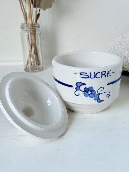 Vintage French blue and white studio pottery sugar bowl with lid, photographed on a white surface.