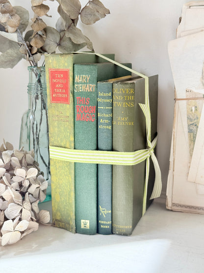 Bundle of vintage sage and olive green cloth books with red spine detail tied with a pale ribbon for styling